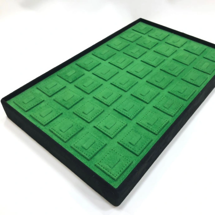 Elegant MDF ring tray with black suede finish and green suede ring holders for a refined ring display.