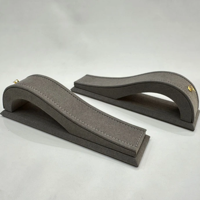Single bracelet stand in gray microfiber with a gold hook for an elegant and secure display.